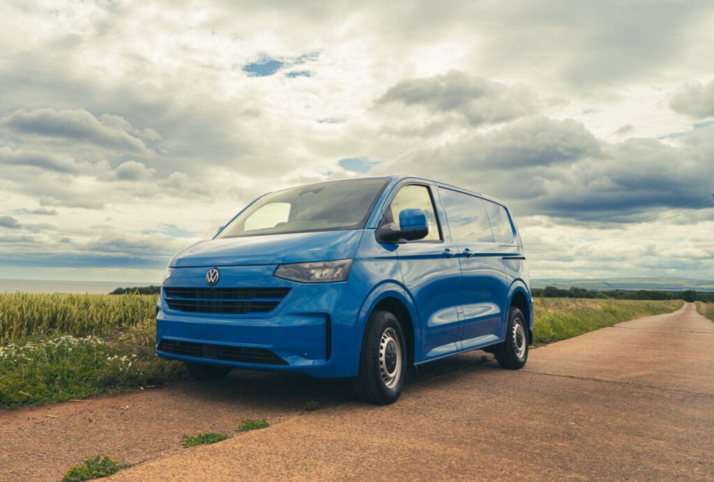 A brand new VW T7 parked in a layby with beautiful countryside behind