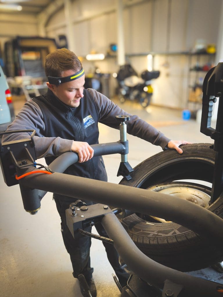 A Service technician using a tyre press funded by UK Grant Funding.