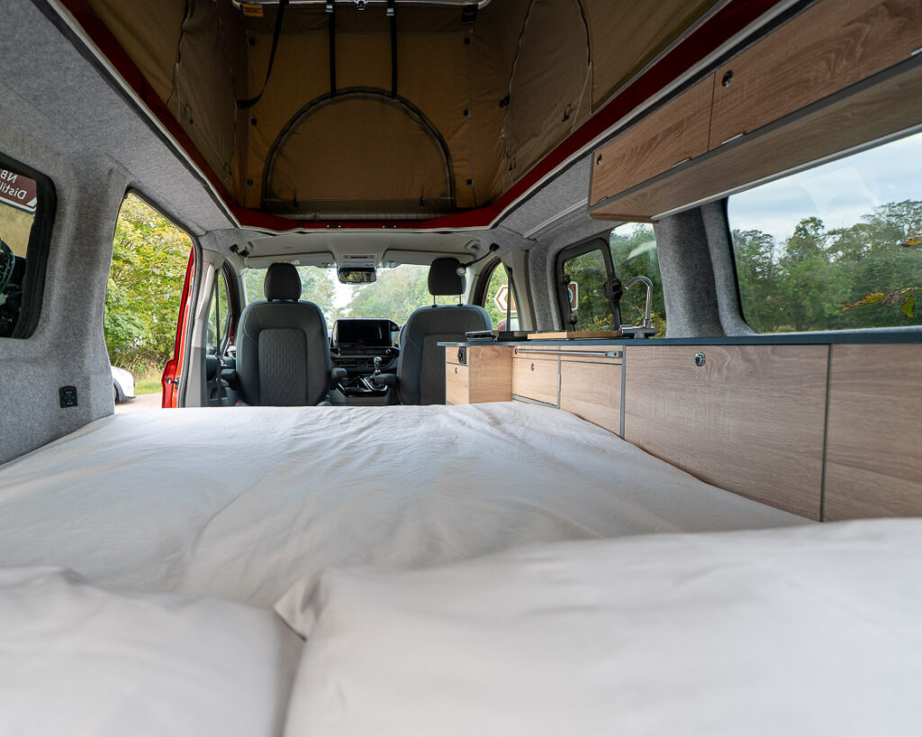 Sleeping area looking forward to cab with long worktop and side window.