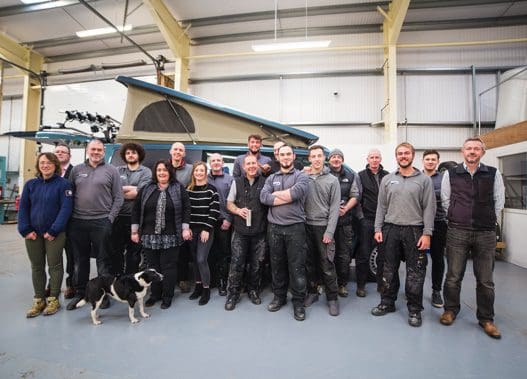 Jerba Campervans Company Team - People standing inside the warehouse and a dog on the left