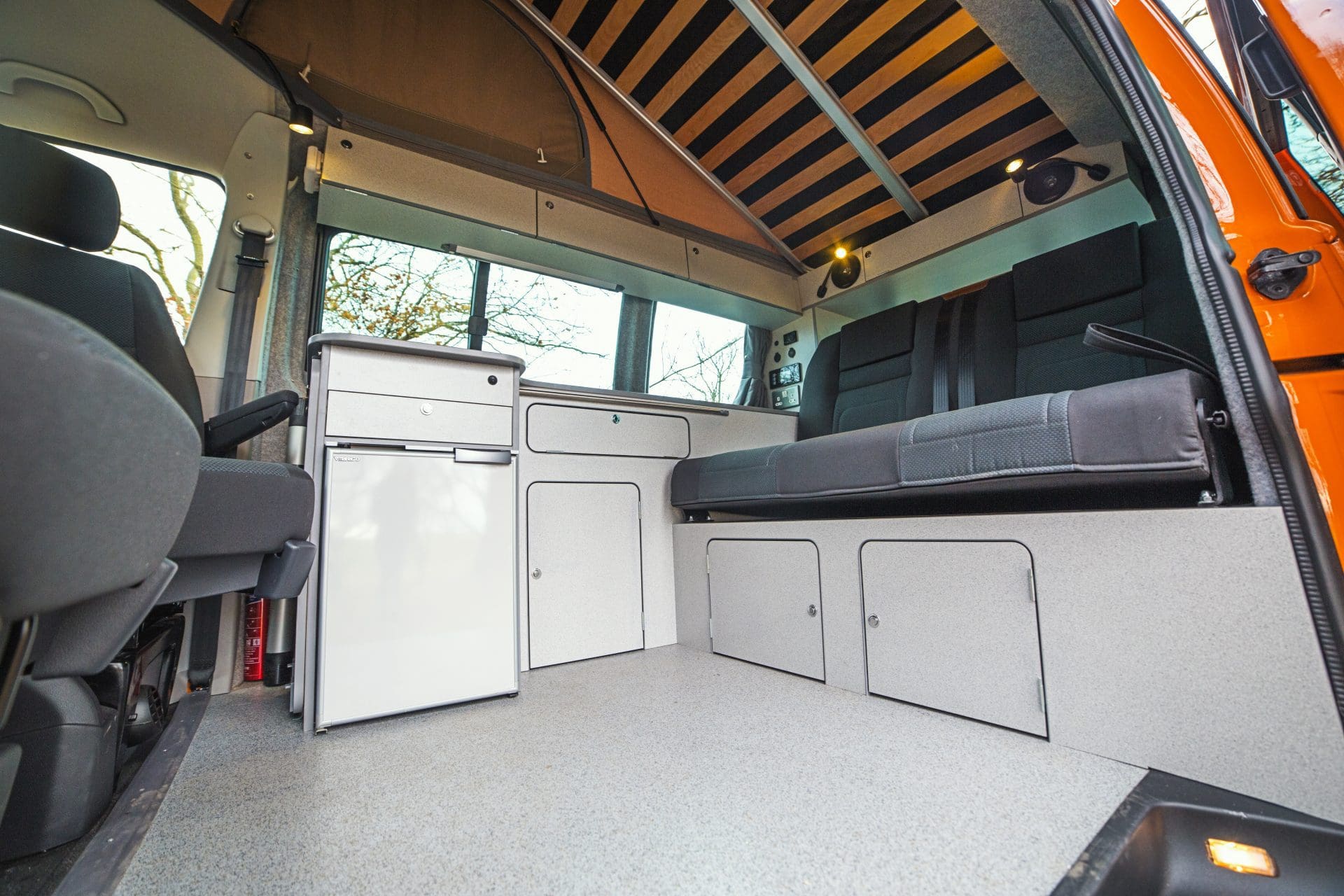 Campervan Interior - light coloured cupboards and black seats