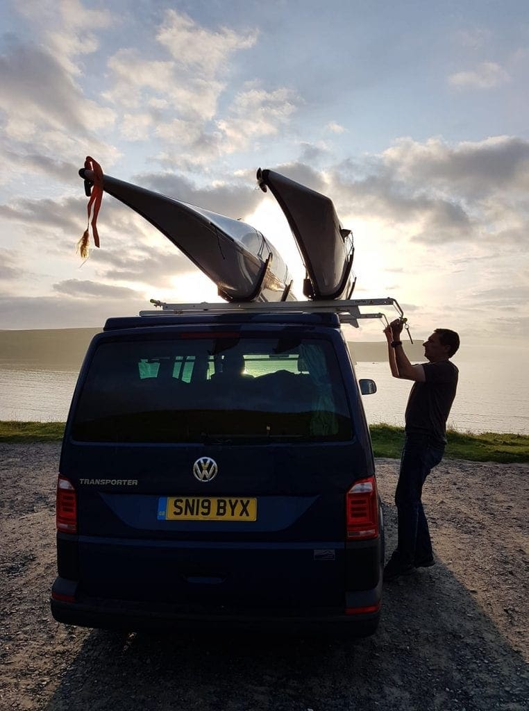 A man on the beach near the campervan