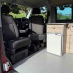 Front seats of a Red 2023 VW T6.1 Transporter Jerba Campervans Tiree Conversion.